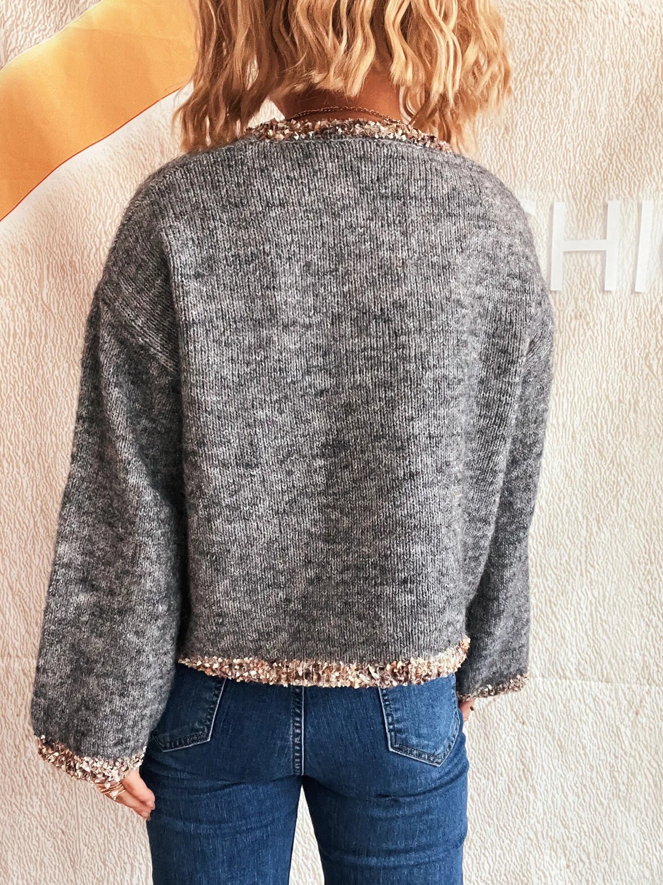 Dark gray cropped round-neck sweater, back view, rose-gold sparkling trim at hem