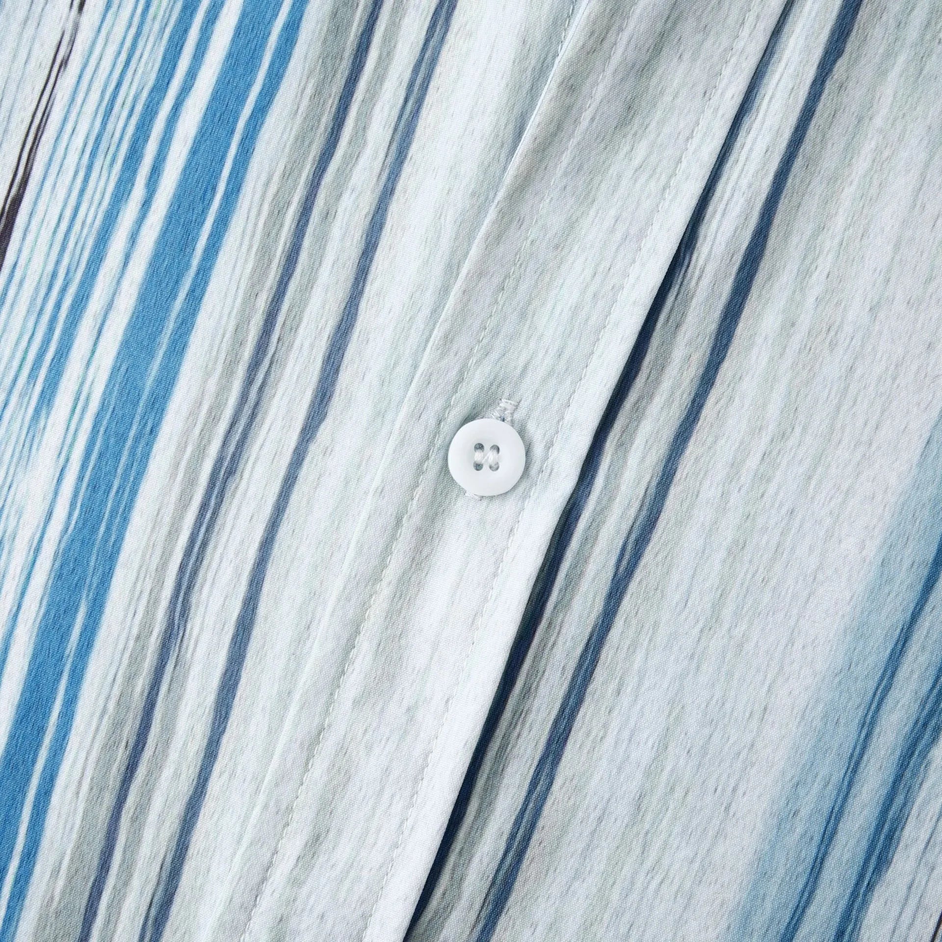 Button-up shirt with white button placket and pastel blue stripe pattern