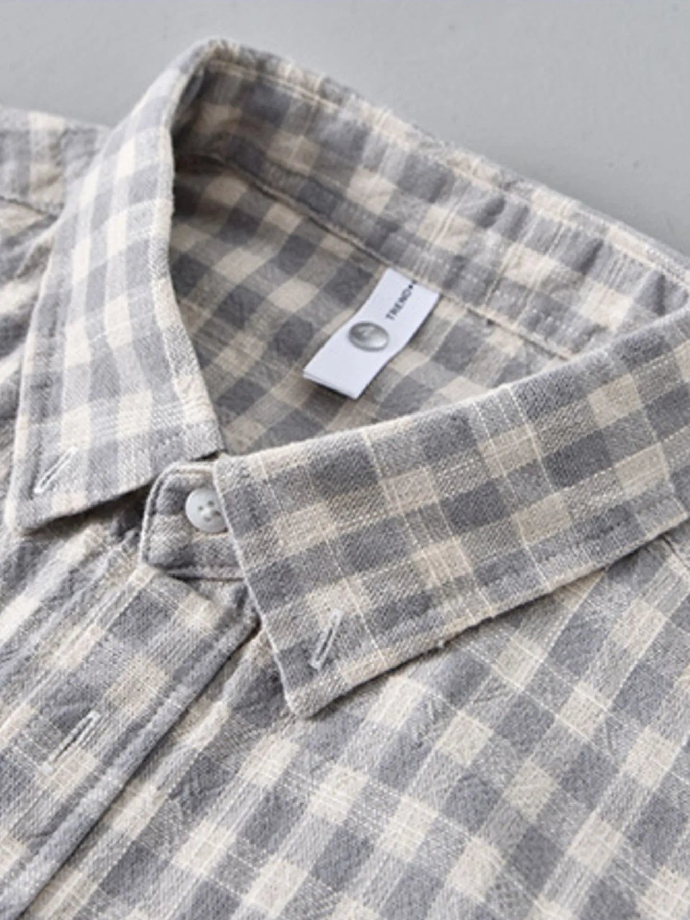 Gray plaid button-up shirt close-up of collar and neck label