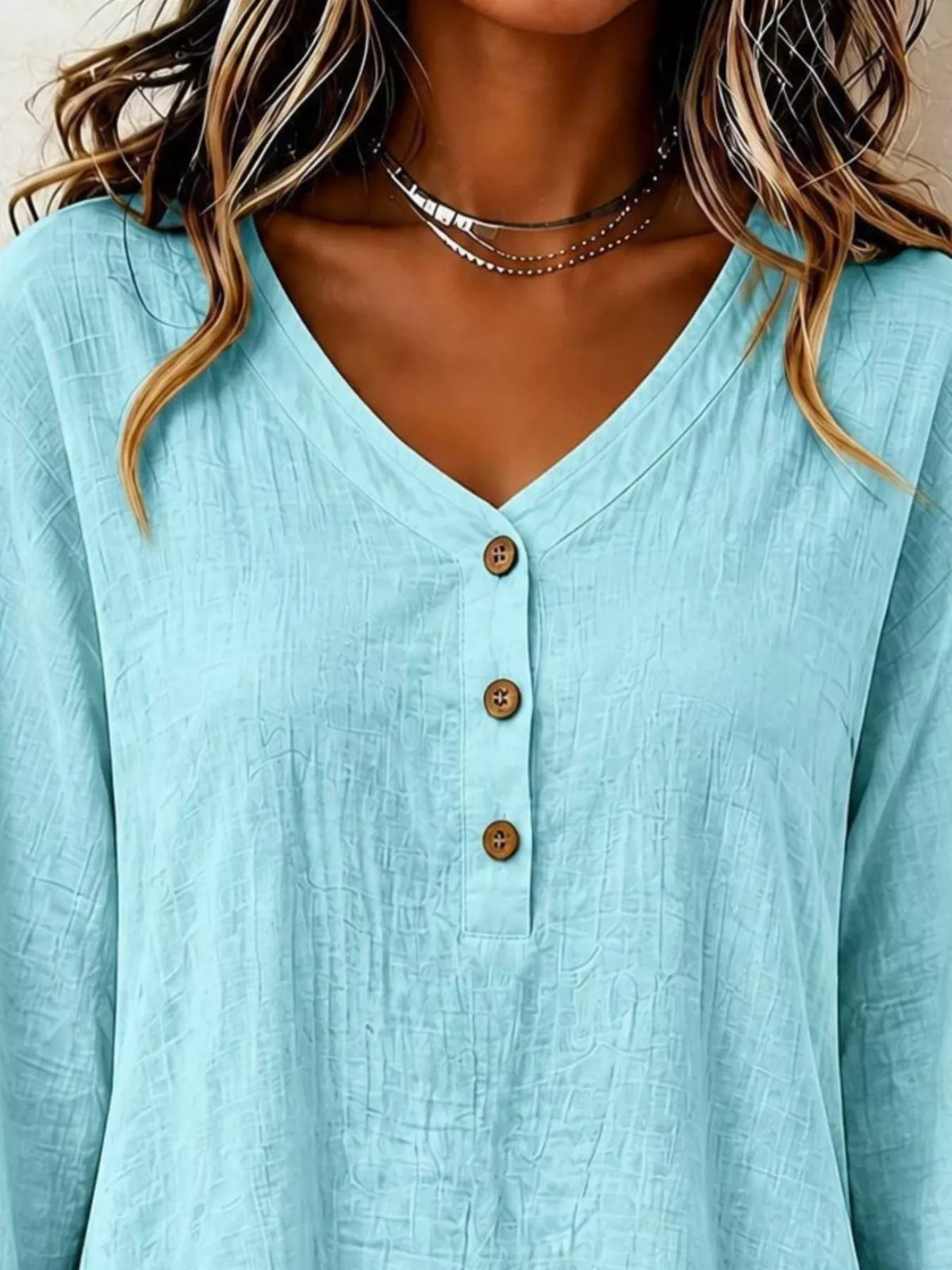 Light blue v-neck long-sleeve blouse with button placket and ruffled hem