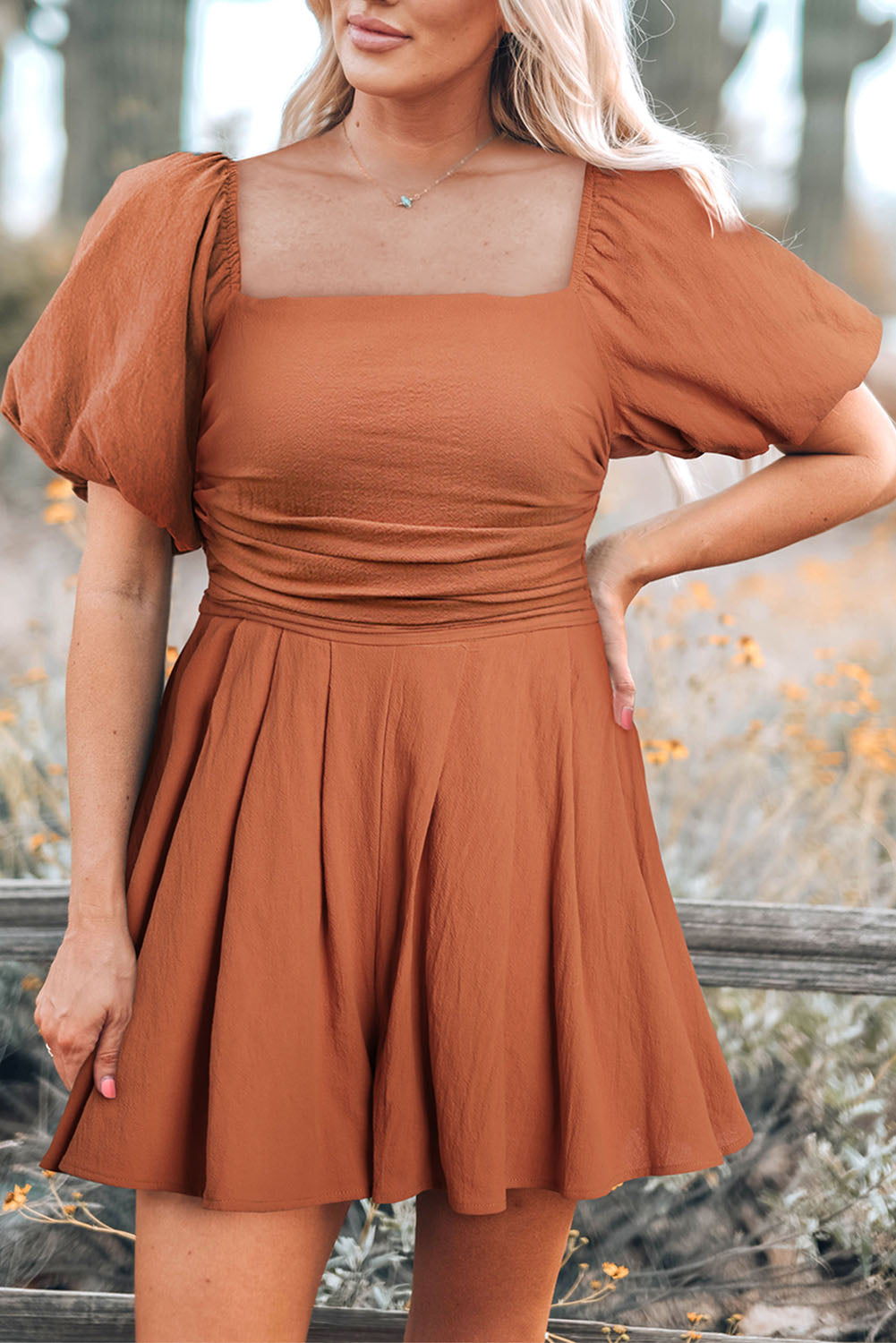 Rust square-neck pleated romper with puff sleeves and side pockets