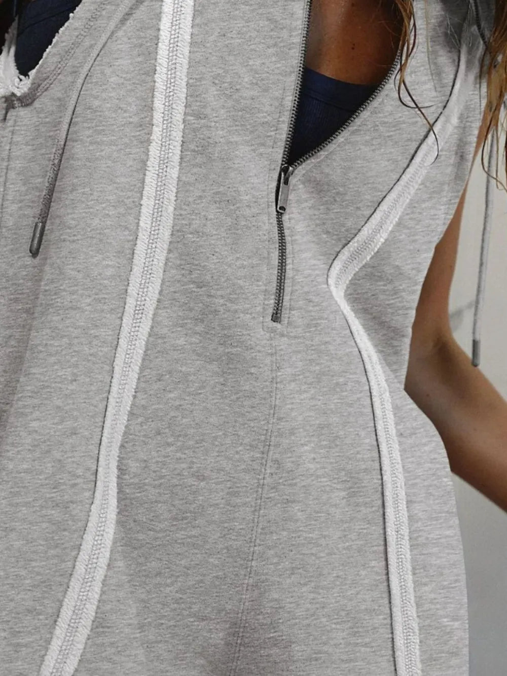 Gray half-zip hooded sleeveless romper with vertical zipper detail at the chest