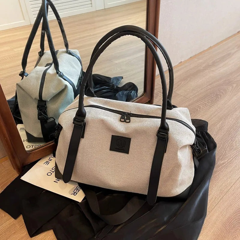 Large polyester duffle bag in cream with black contrast handles and front logo patch