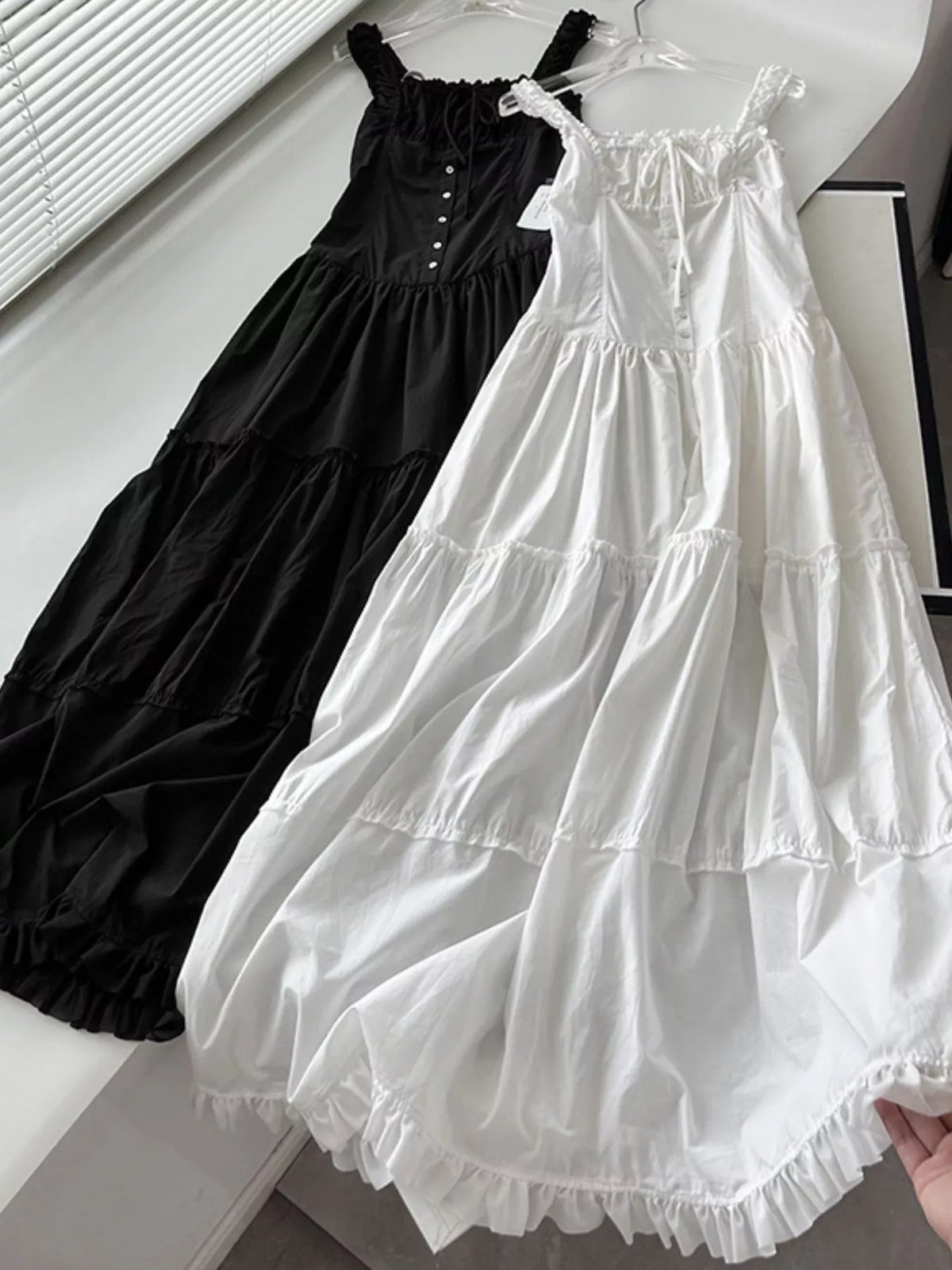 White cotton maxi dress with ruffled square neck, tiered skirt, and tie shoulder straps
