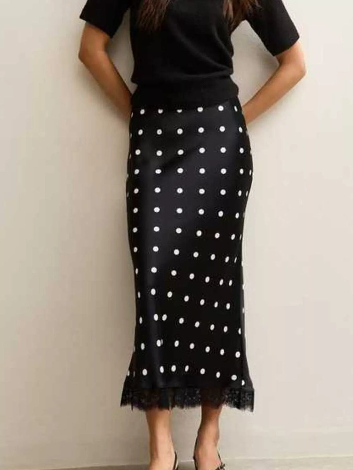 Black midi skirt with white polka dots and lace trim along the hem