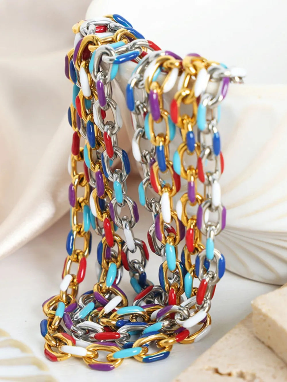 Stacked multicolor chain bracelets with gold, silver, purple, red, and blue links