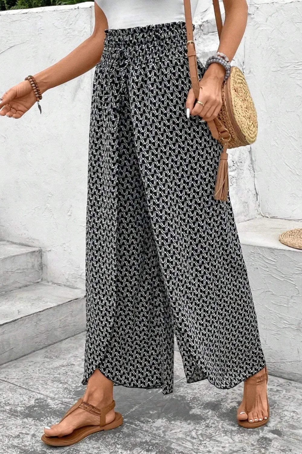 Black patterned wide-leg pants with elastic waistband and side slit