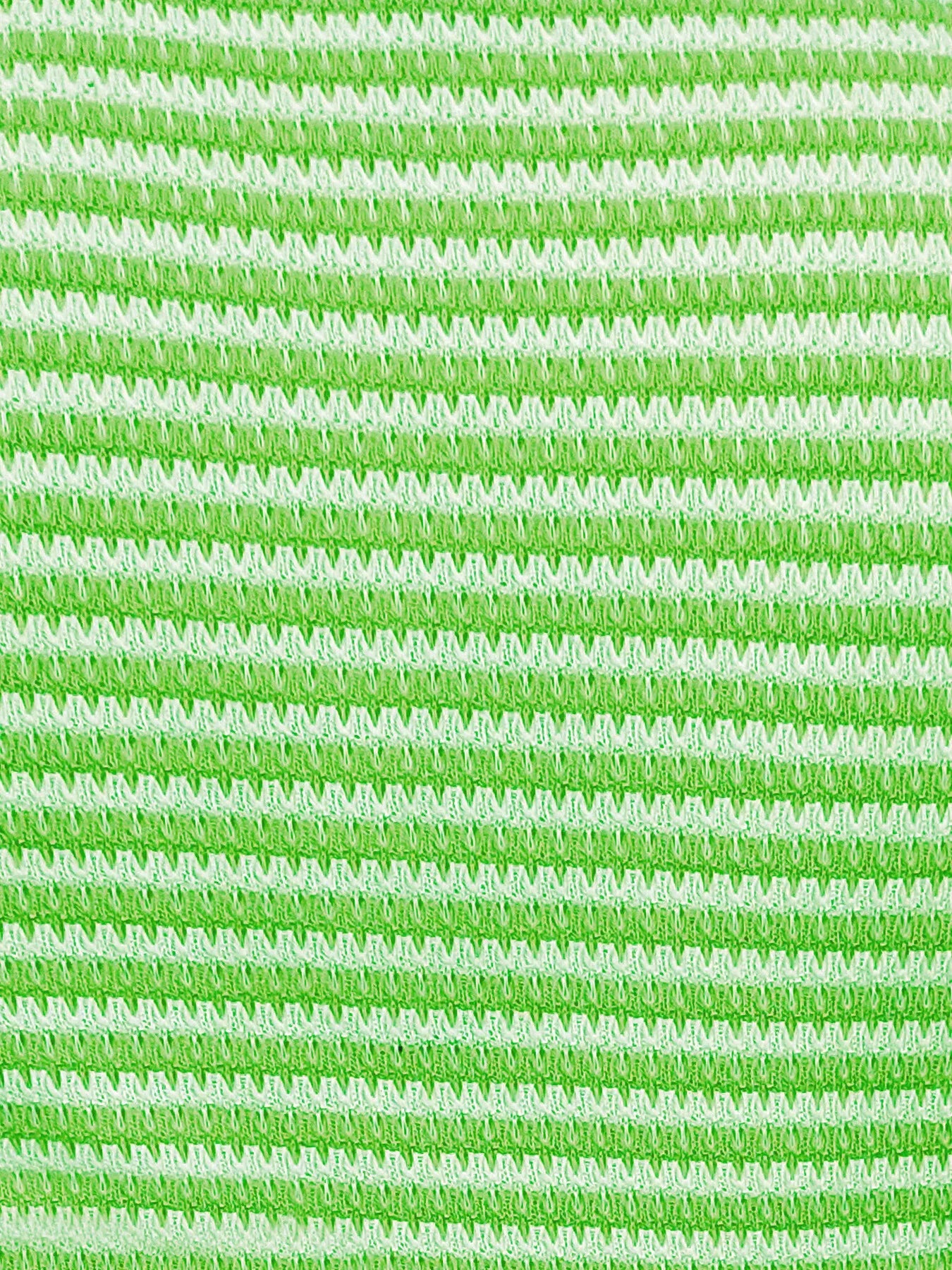 Close-up of neon green and white striped knit tank top fabric