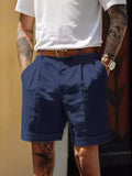 Men's navy pleated shorts with belt loops and brown buckle