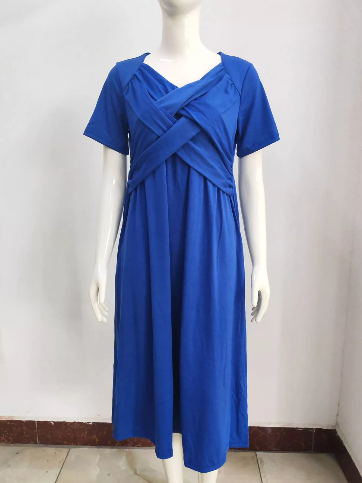 Blue midi dress on mannequin with crisscross V-neck and short sleeves, gathered waist