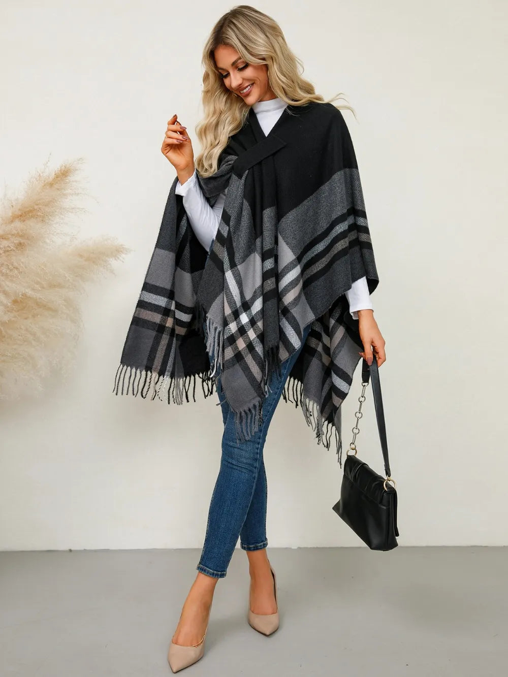 Plaid contrast poncho with fringe trim, black base with gray windowpane and stripe bands
