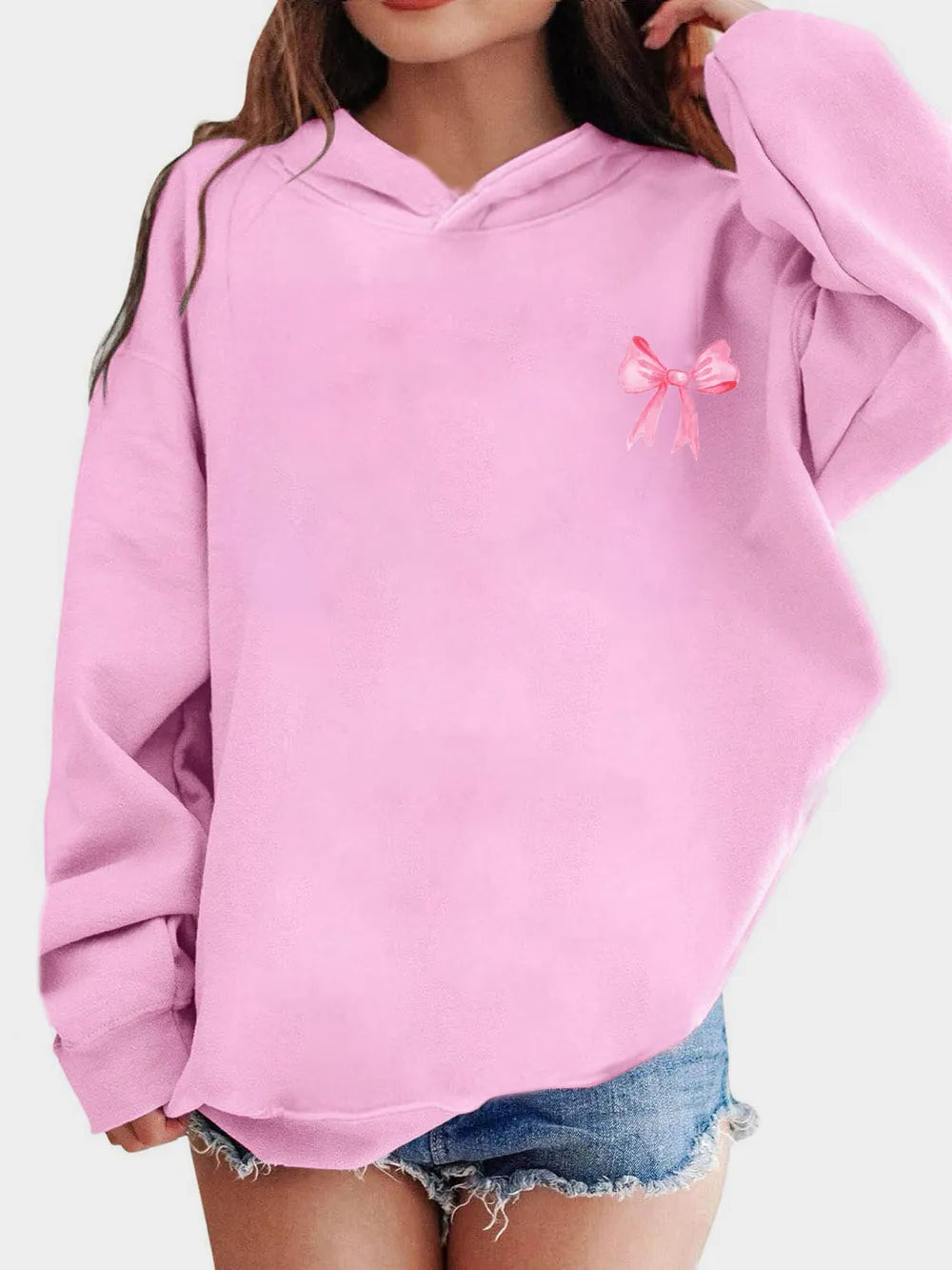 Light pink long-sleeve hoodie with small pink bow detail on chest