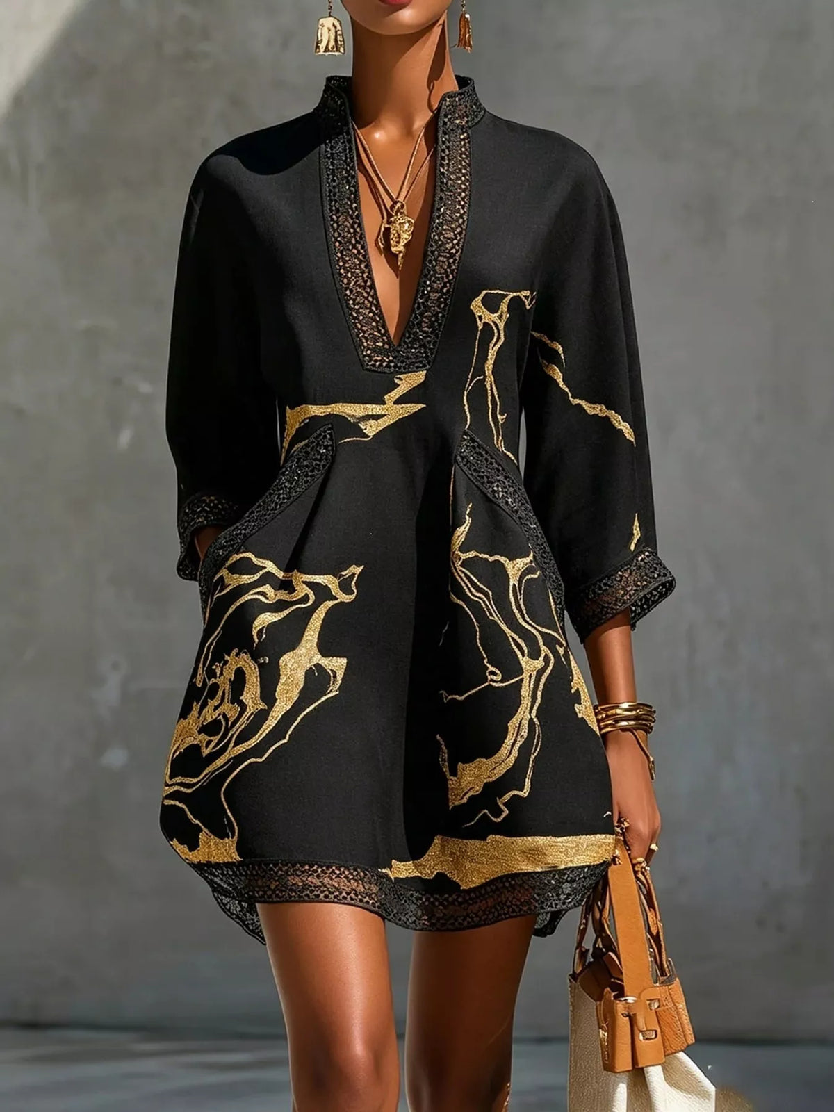 Black mini dress with V-neck lace edging and gold patterned print, front view