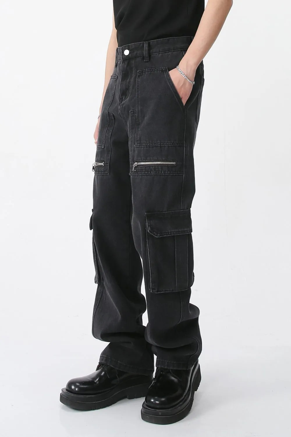 Dark loose-fit cargo jeans with stacked front pockets and flap closures