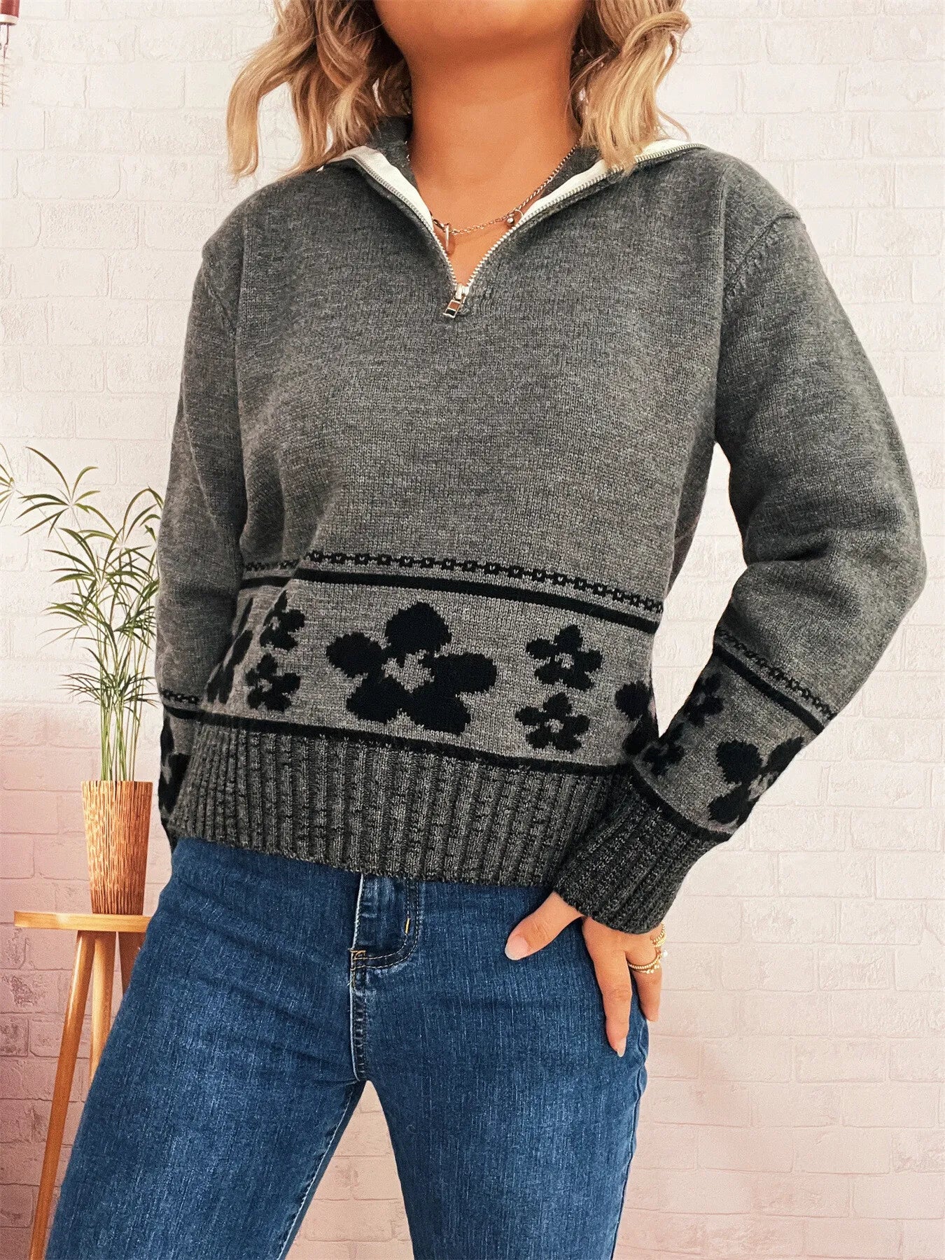 Gray long-sleeve sweater with half-zip collar and black flower band on hem