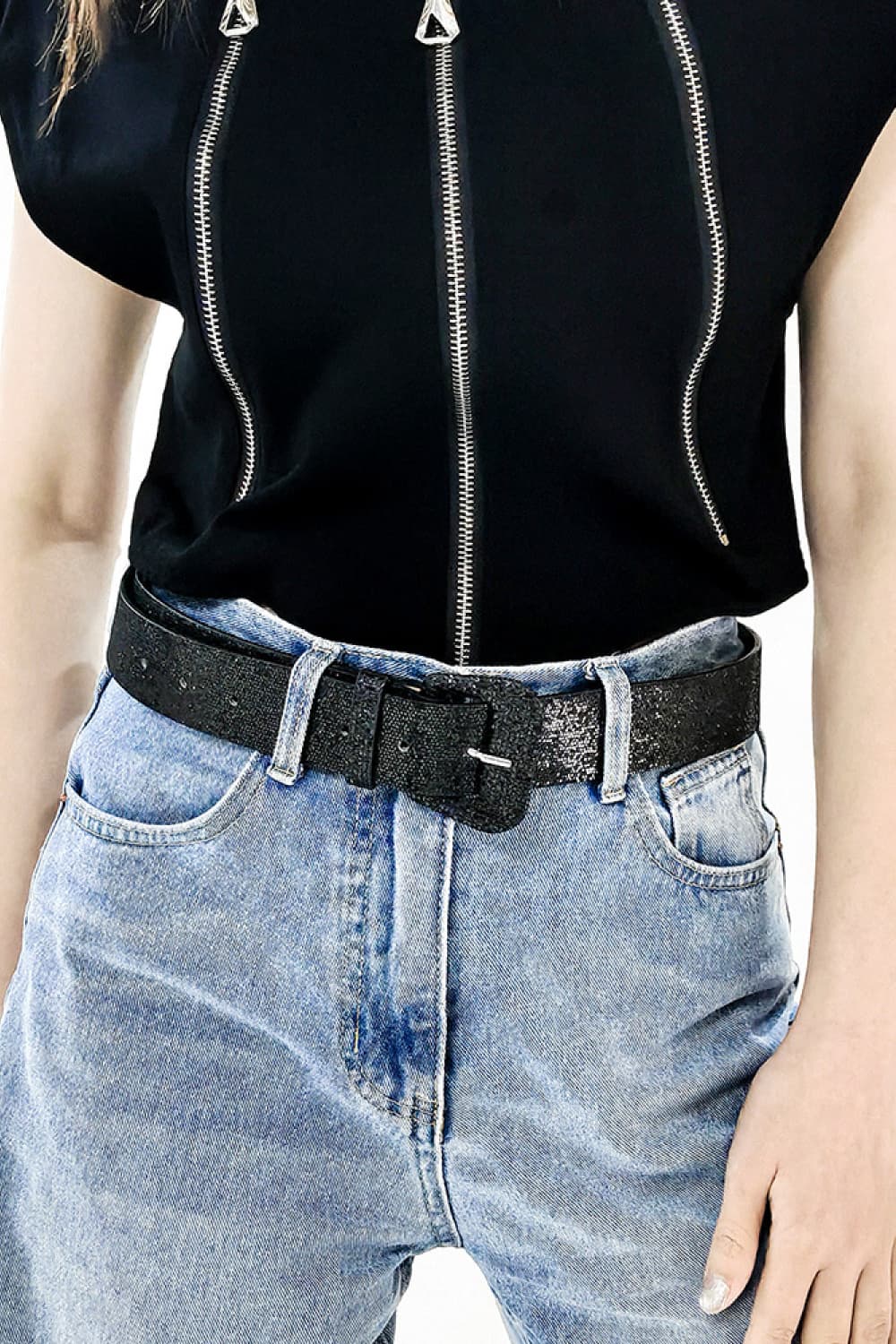 Black glitter vegan leather belt with rectangular buckle on light wash jeans
