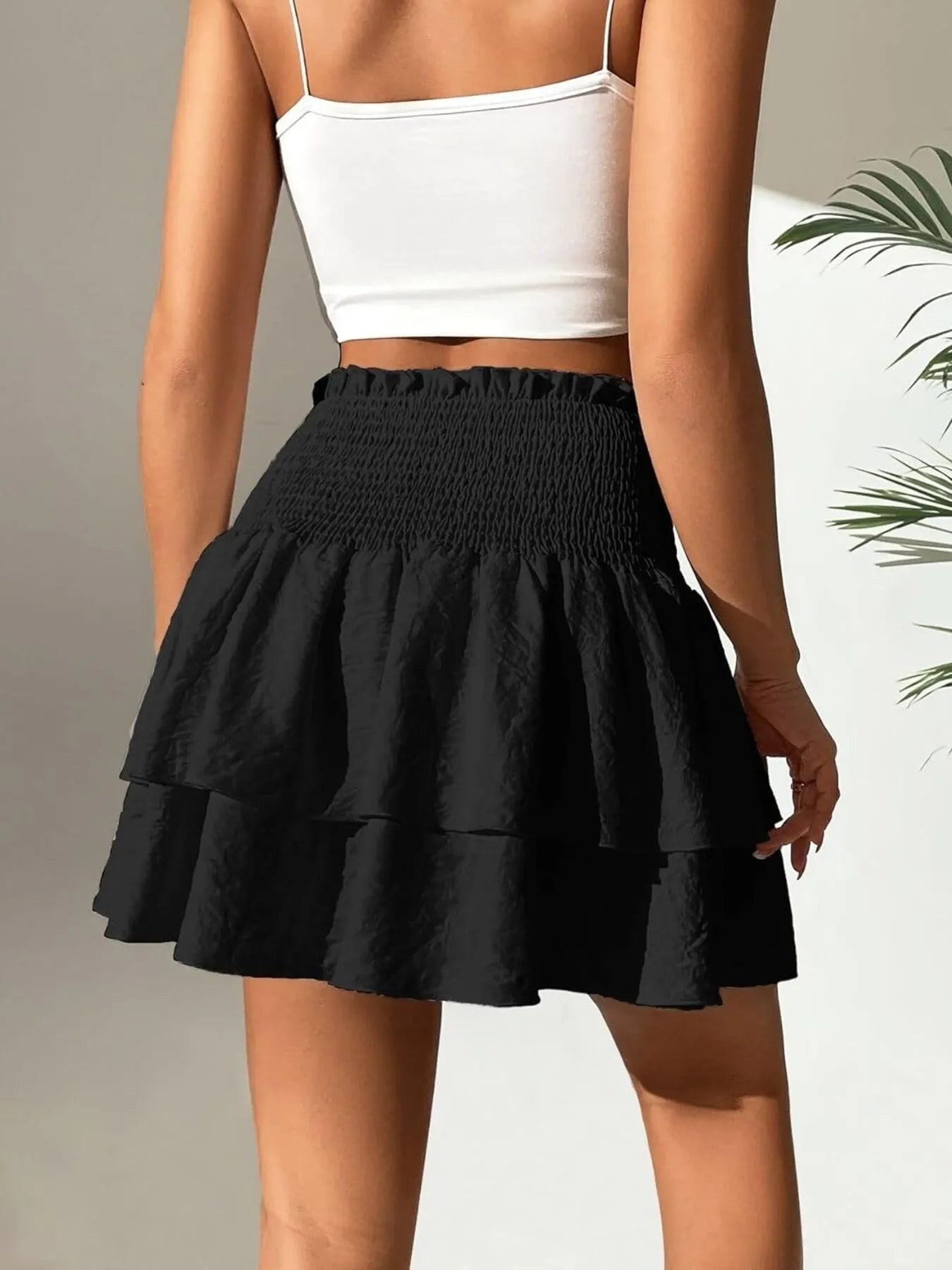 Black smocked mini skirt with wide tiers and ruched waistband