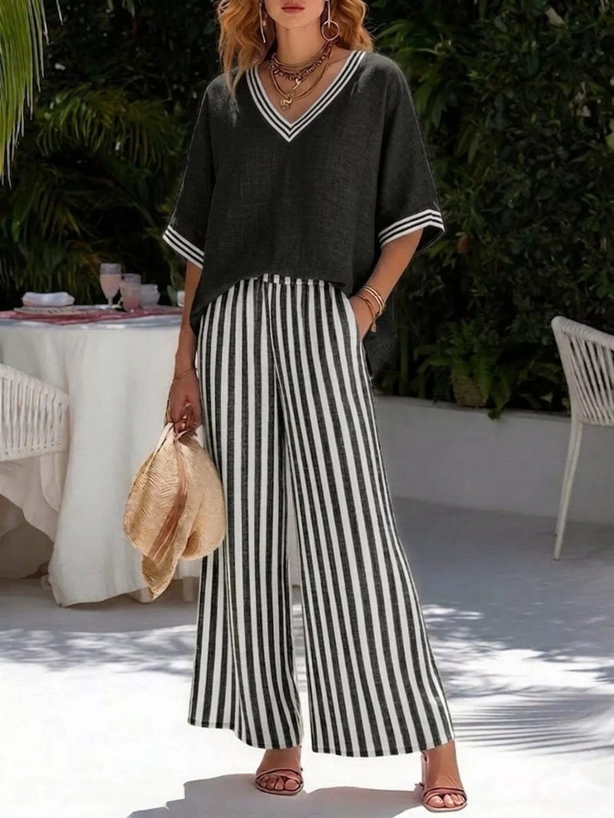 Black V-neck loose top with striped wide-leg pants, two-piece casual set.