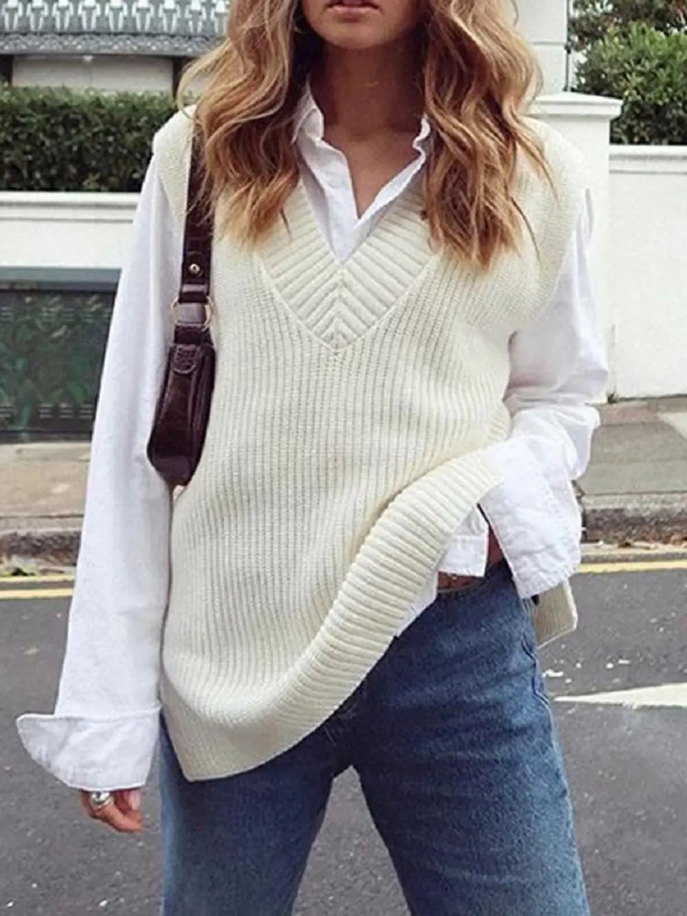 Cream ribbed V-neck sleeveless sweater vest with soft knit texture and V front.