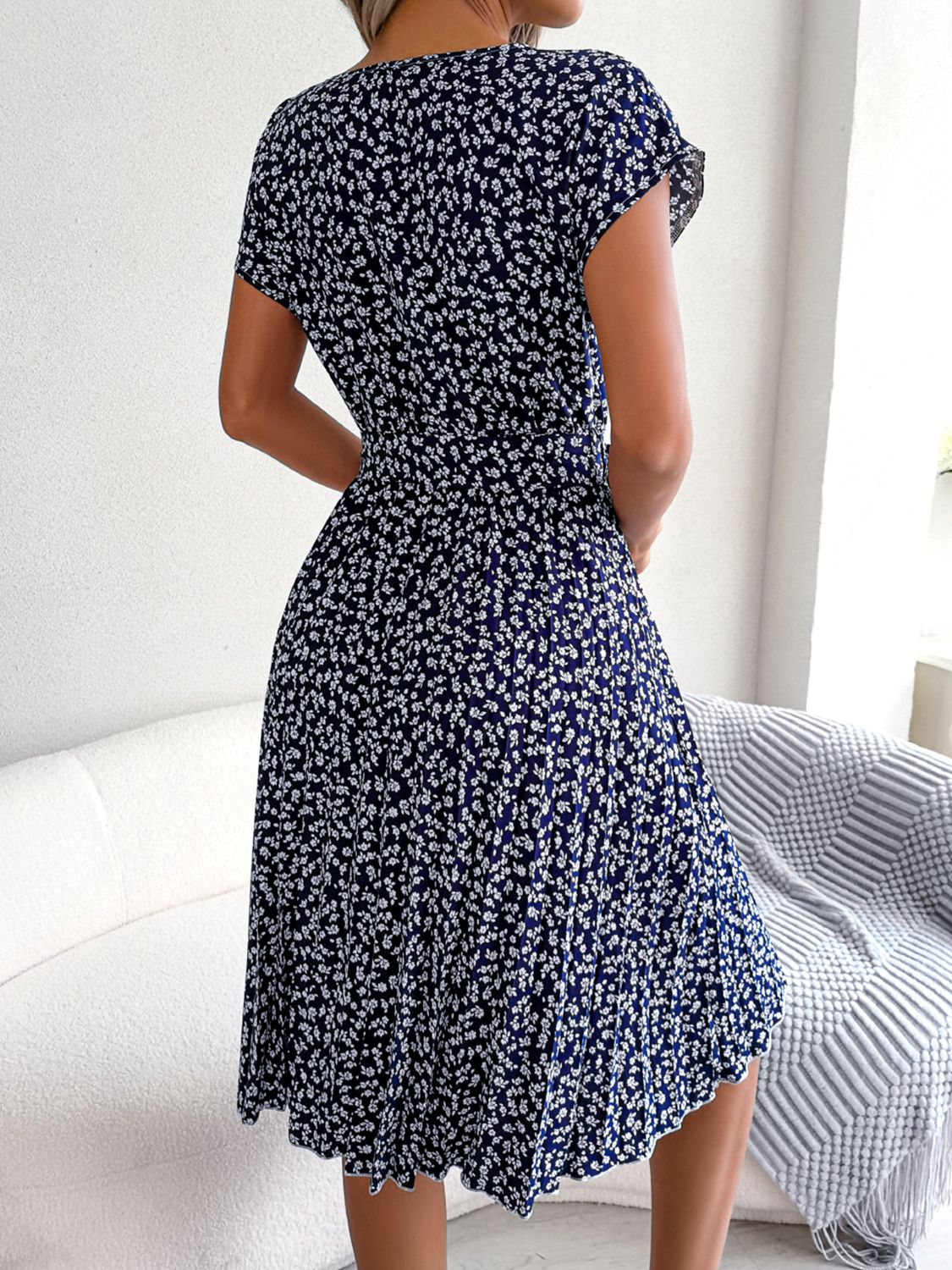 Navy ditsy floral pleated belted dress with short sleeves, back view