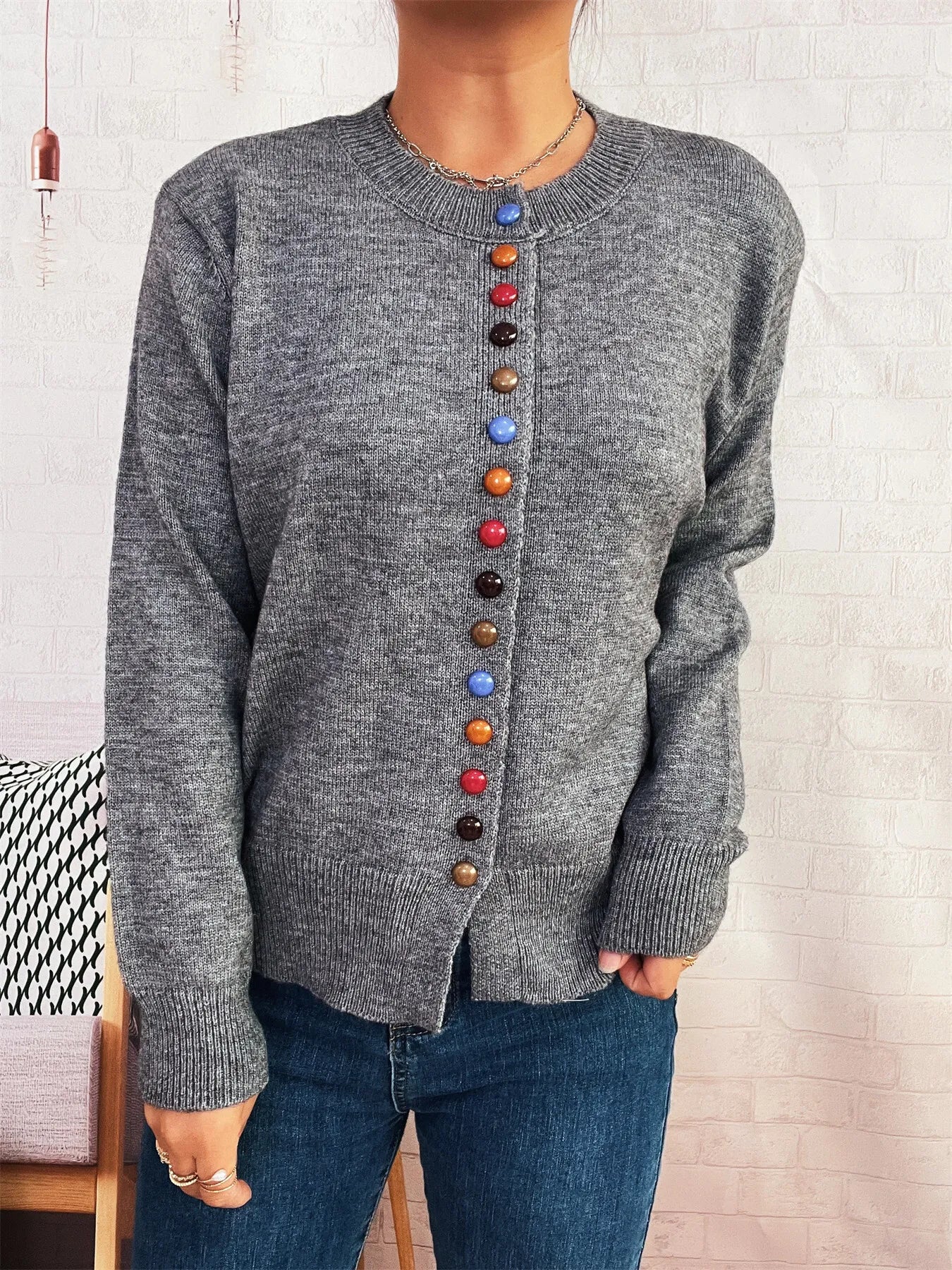 Gray button-front cardigan with crew neck and vertical row of colorful buttons