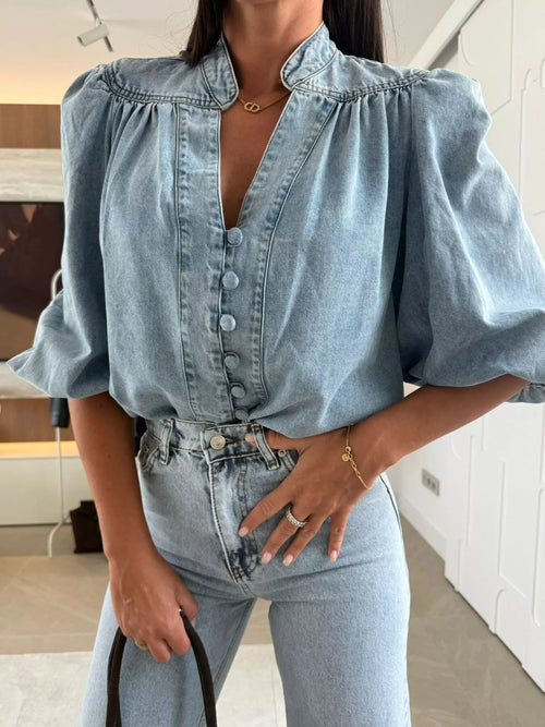 Sky-blue denim button-down top with gathered neckline and puff sleeves, front buttons.