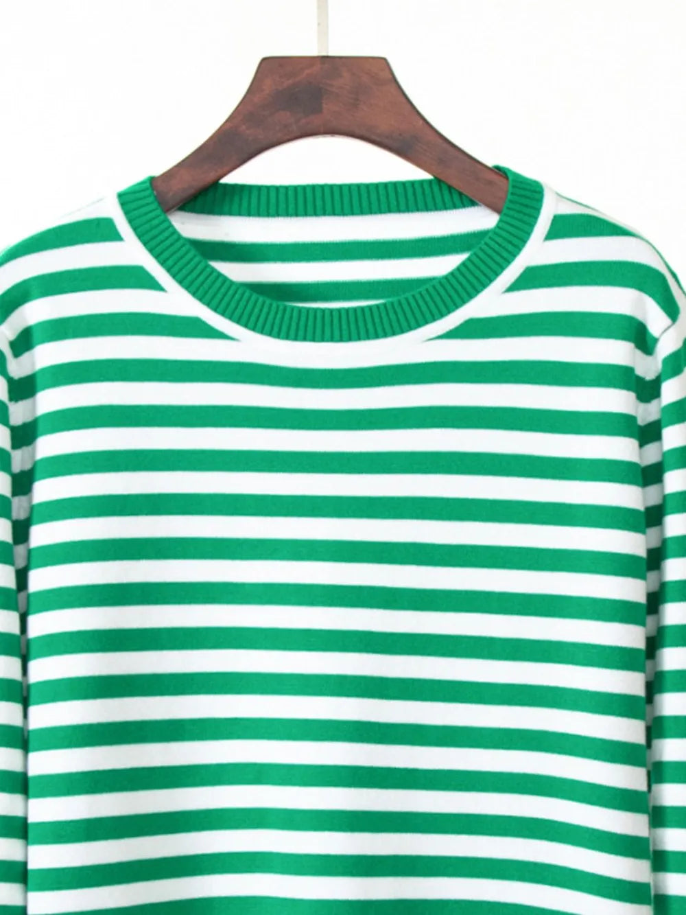 Striped sweater close-up: green and white horizontal stripes, crew neck.