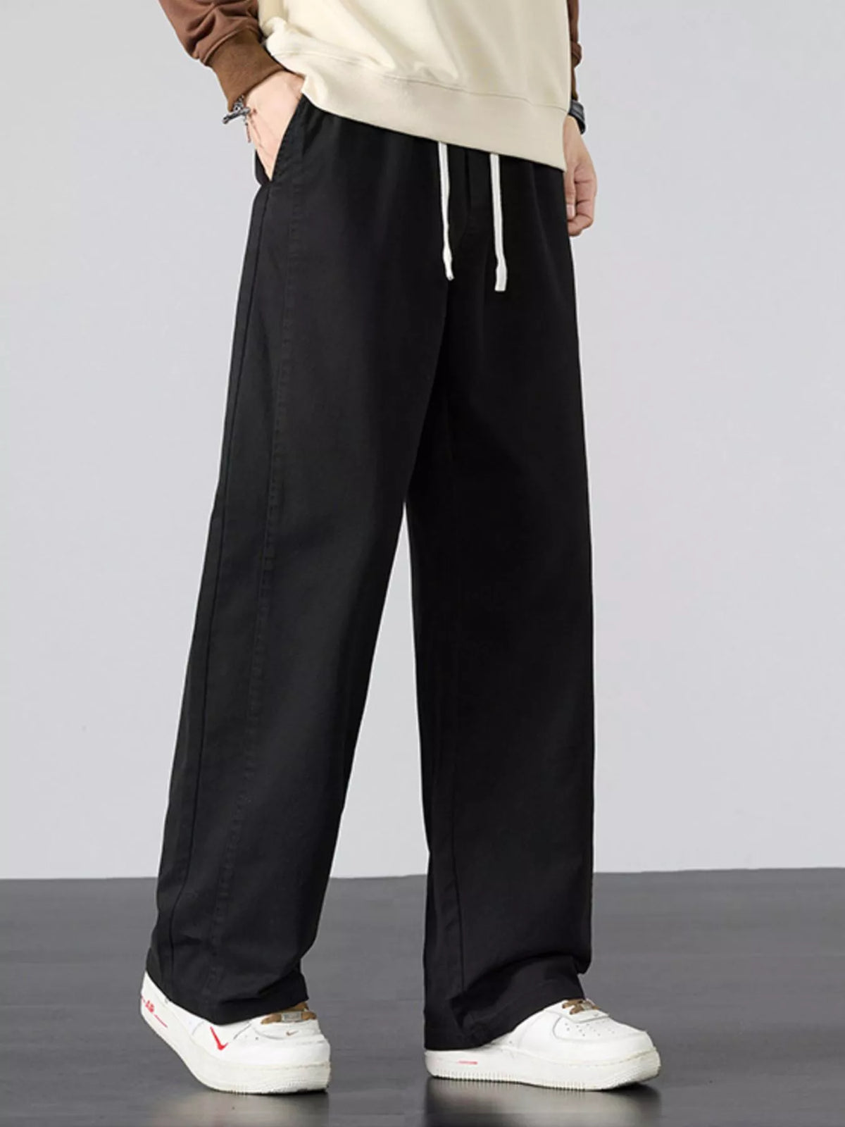 Mens black wide-leg drawstring pants with relaxed straight legs and side seam pockets