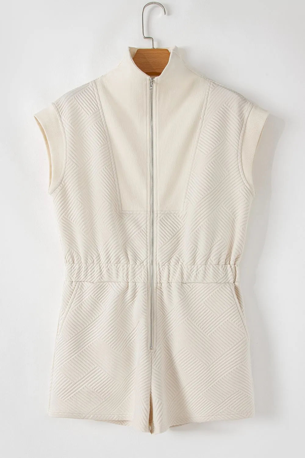 Cream textured zip-front romper, sleeveless with front pockets and waist seam