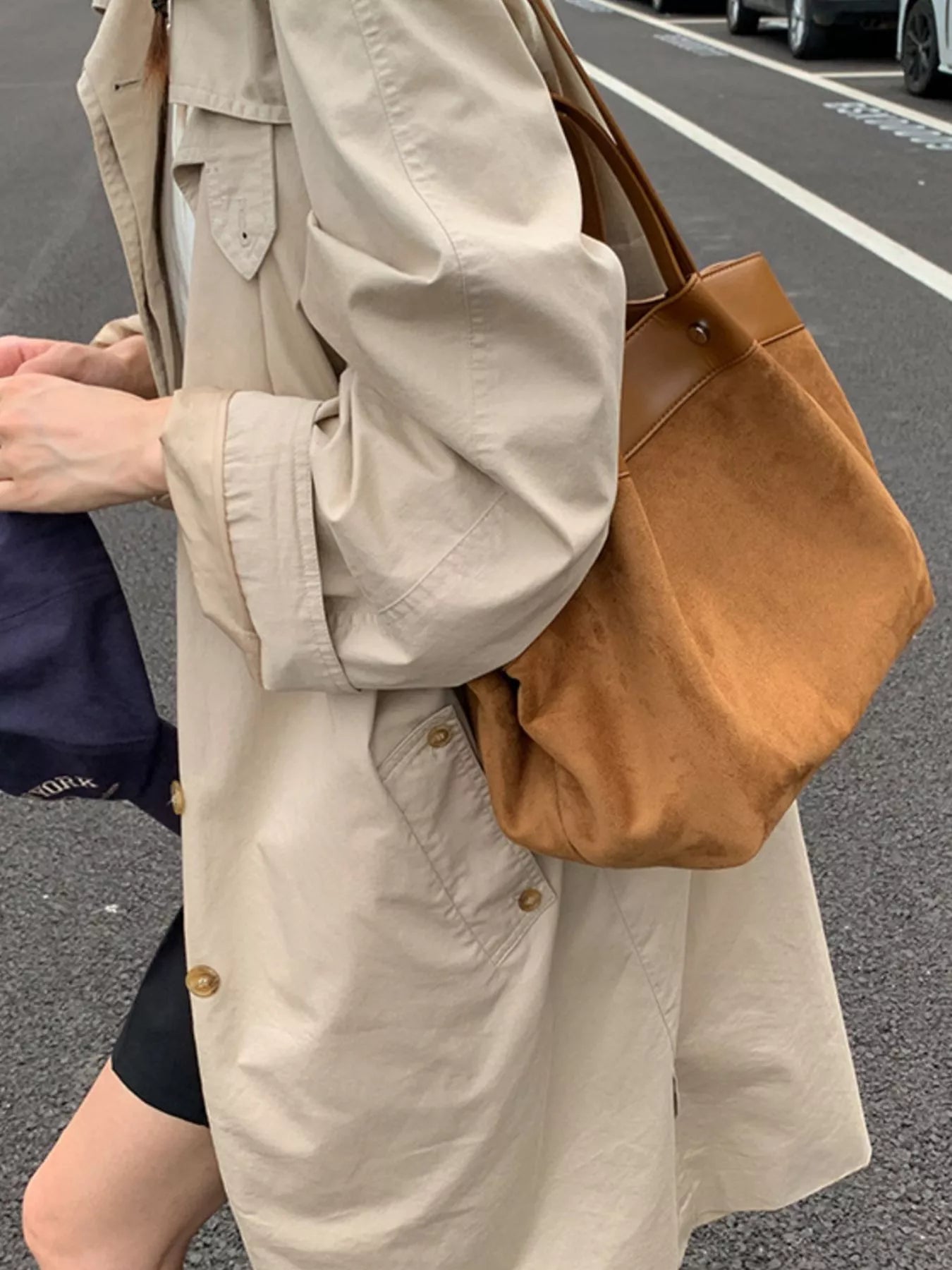 Brown suede shoulder bag with leather handles, angled side view
