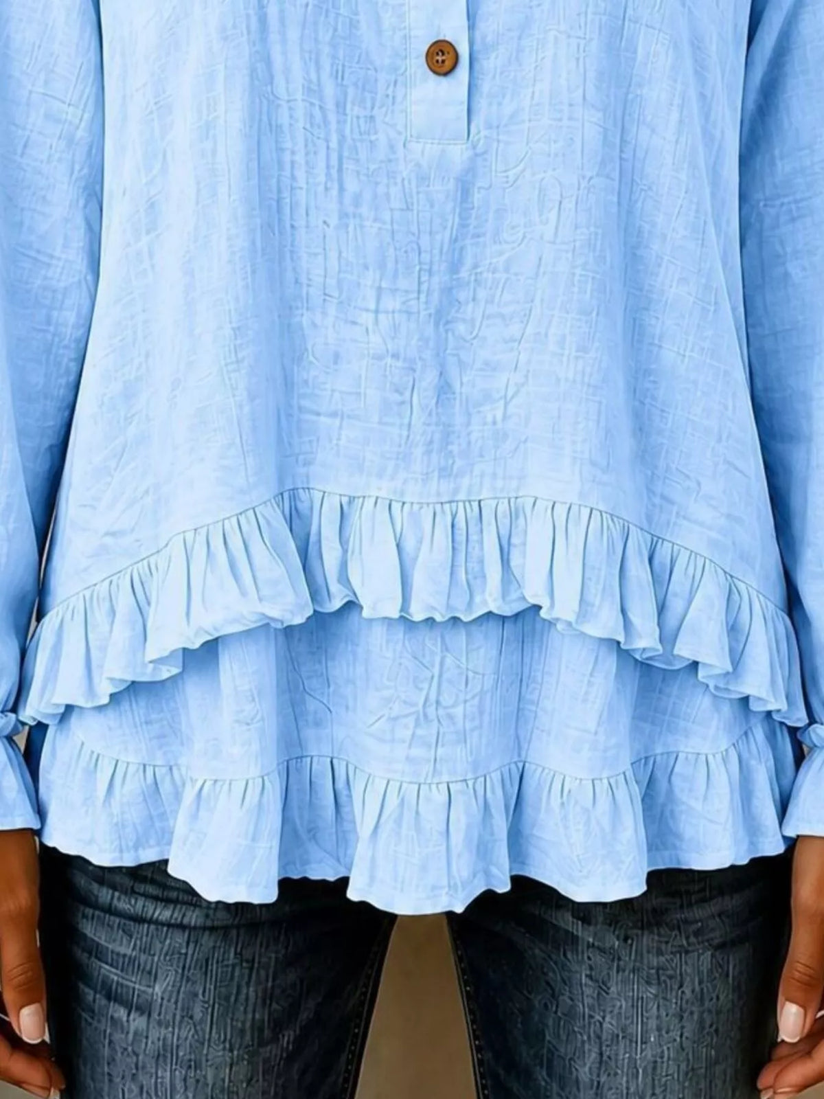 Light blue blouse showing tiered ruffle hem with elastic cuffs
