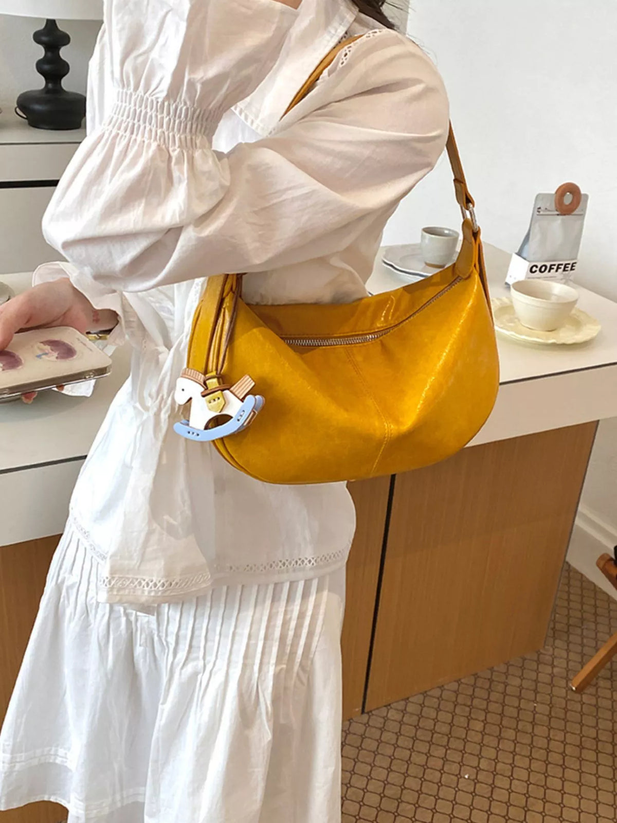 Medium yellow vegan leather shoulder bag with zipper top and hanging charm