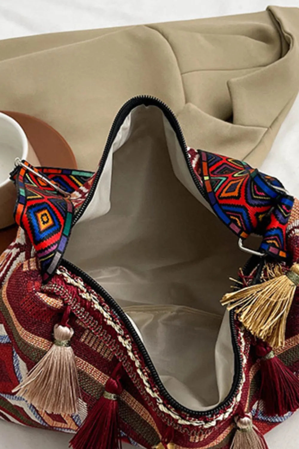 Tassel shoulder bag with geometric fabric trim and multicolor tassels, open top view