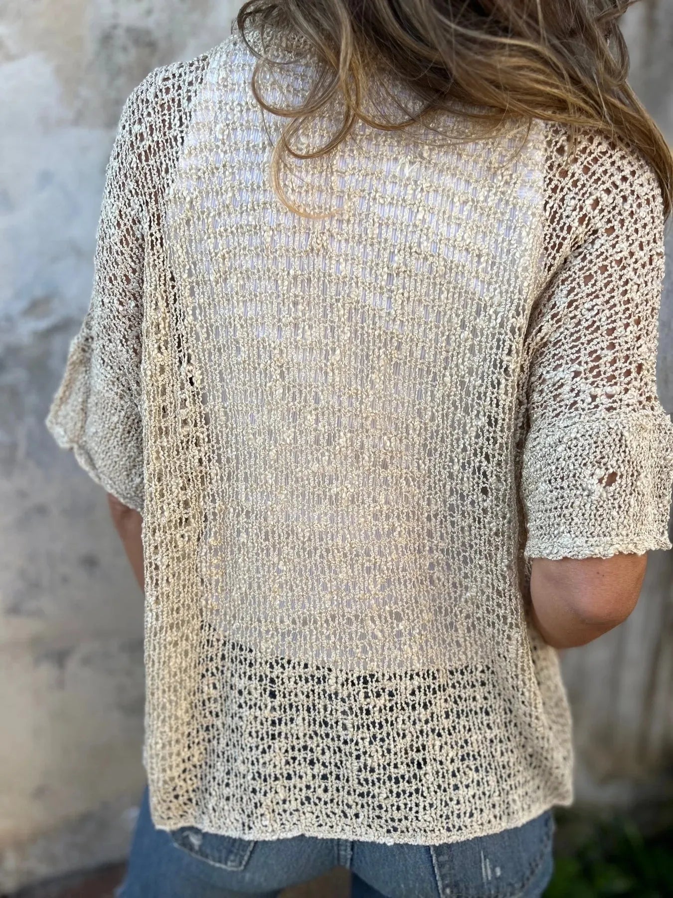 Light cream open-knit half-sleeve cardigan with V-neck and one button at center front