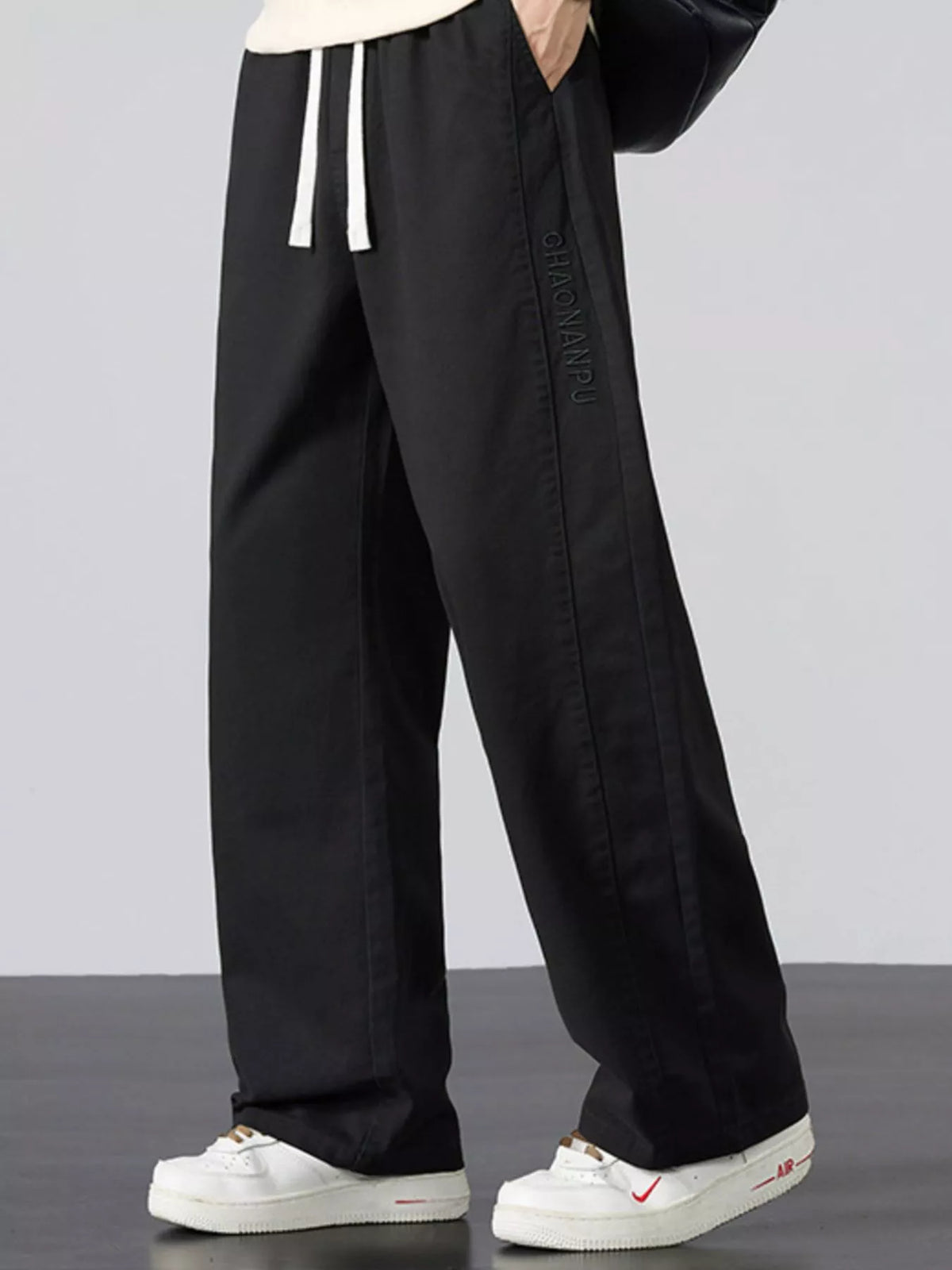 Mens black wide-leg casual pants with elastic waist and white drawstring ties