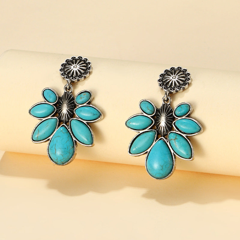 Turquoise flower earrings with oval turquoise petals and silver-tone sunburst caps.