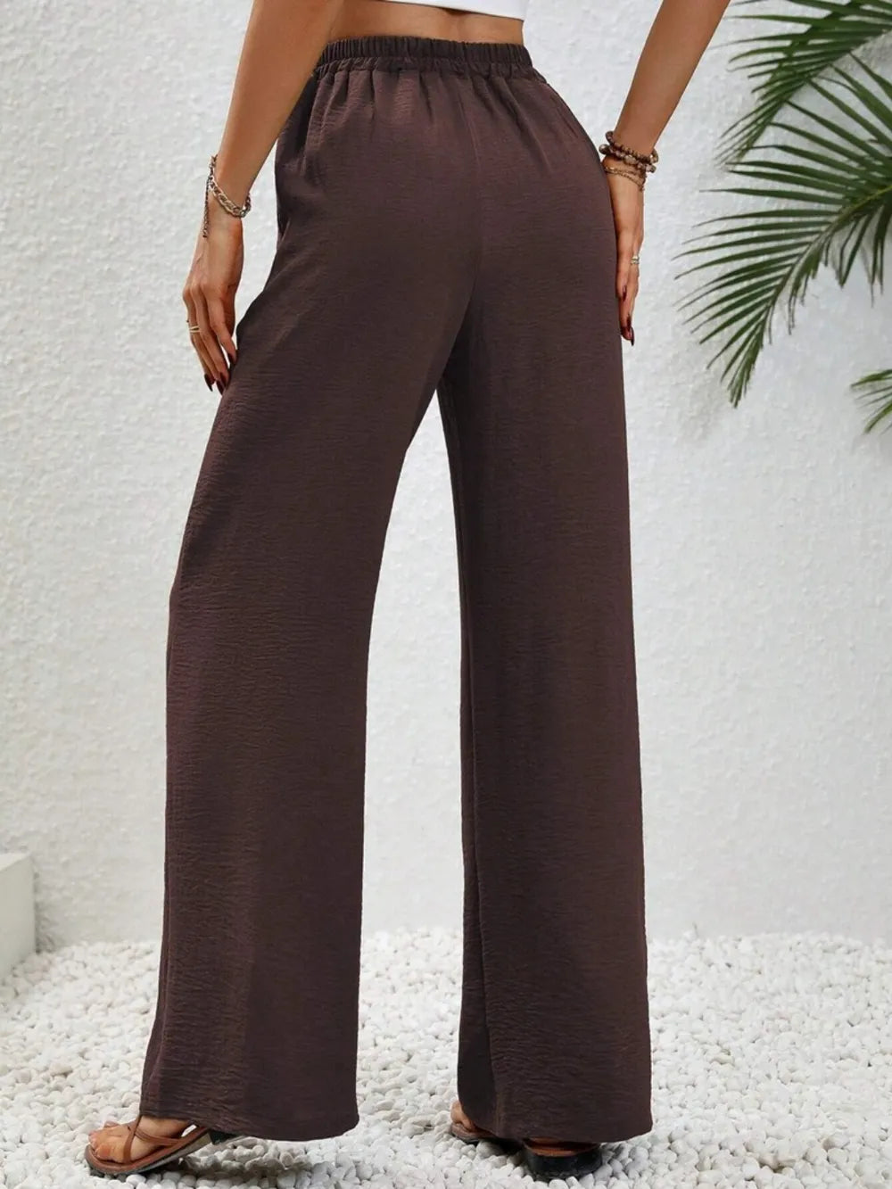 Dark brown wide-leg drawstring pants with elastic waistband and gathered tie waist