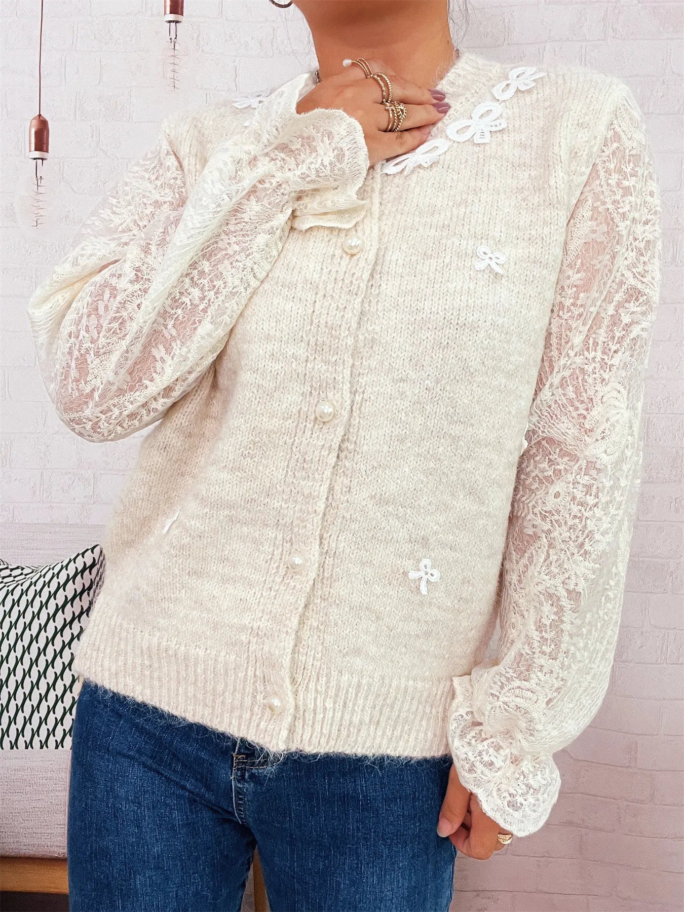 Cream button-up cardigan with lace sleeves, scalloped collar trim, and front buttons