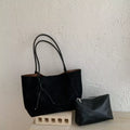 Black suede medium tote bag with two handles, front drawstring pocket, and small zip pouch