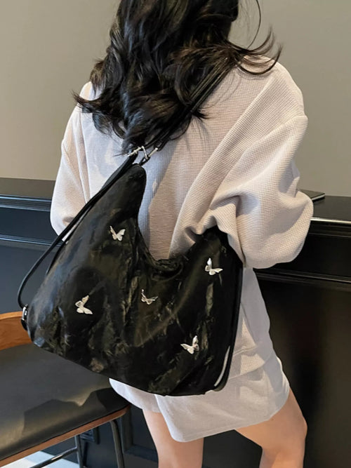 Black shoulder bag with butterfly charm appliques and short handles
