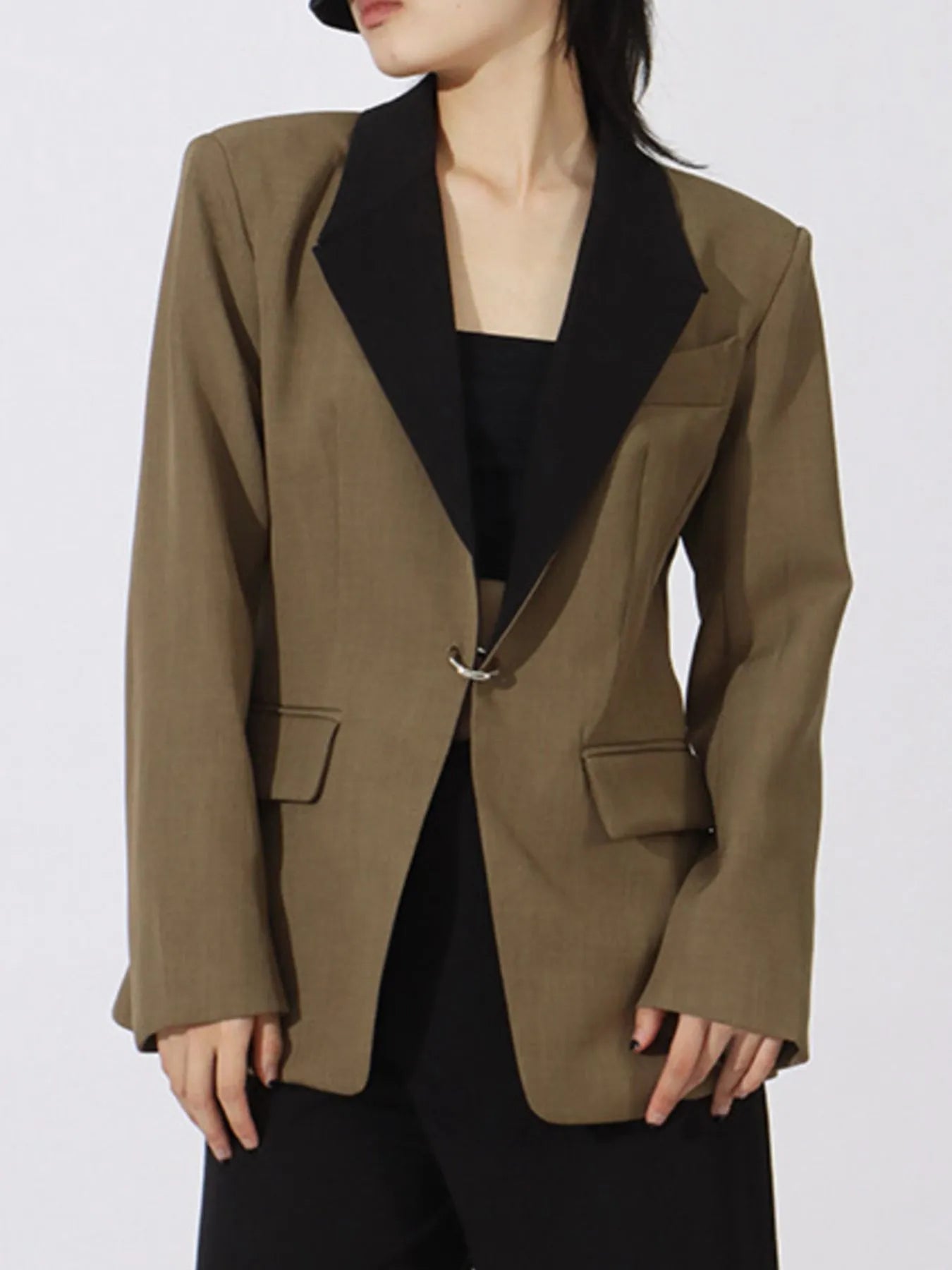Khaki green blazer with black contrast V-neck lapels, flap pockets, and metal front clasp