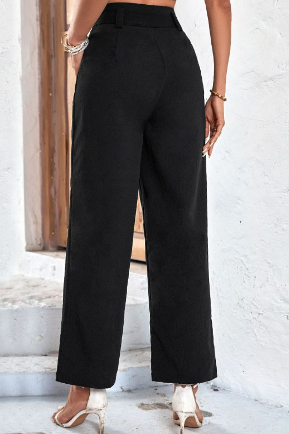 Black high-rise wide-leg pants with wide waistband, straight-on rear view