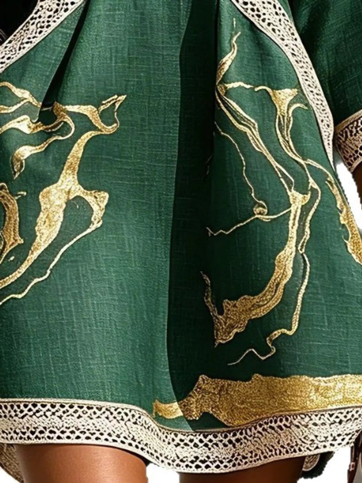 Green mini dress with gold graphic print and white lace trim at hem