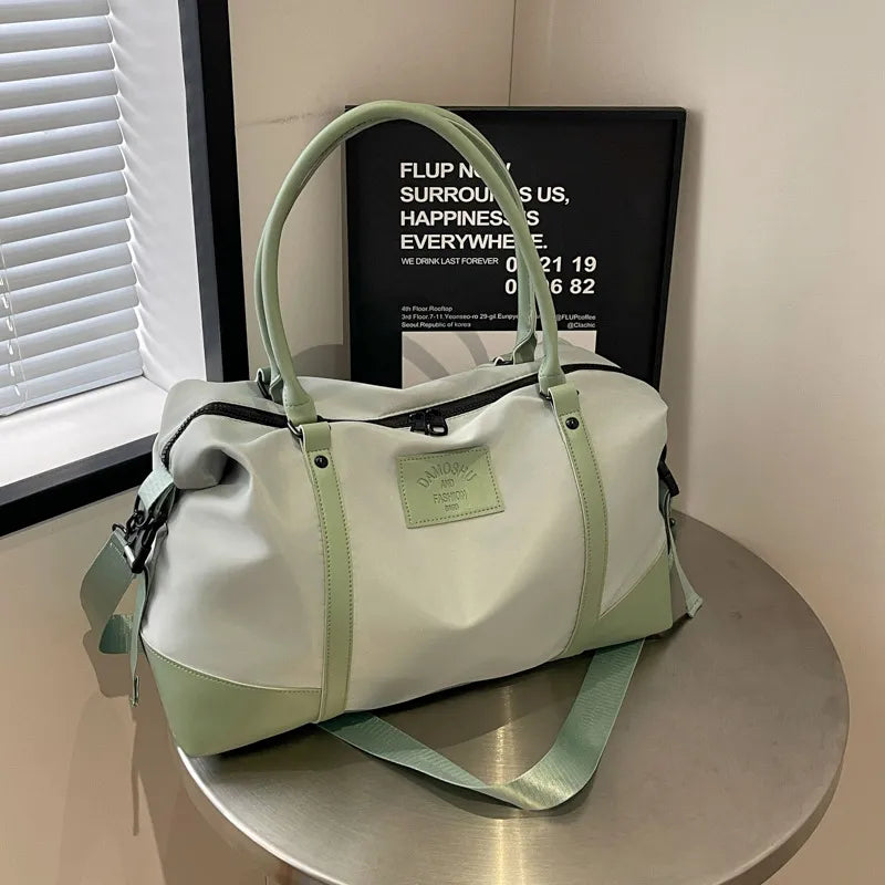 Sage green polyester travel duffel with detachable crossbody strap and top handles