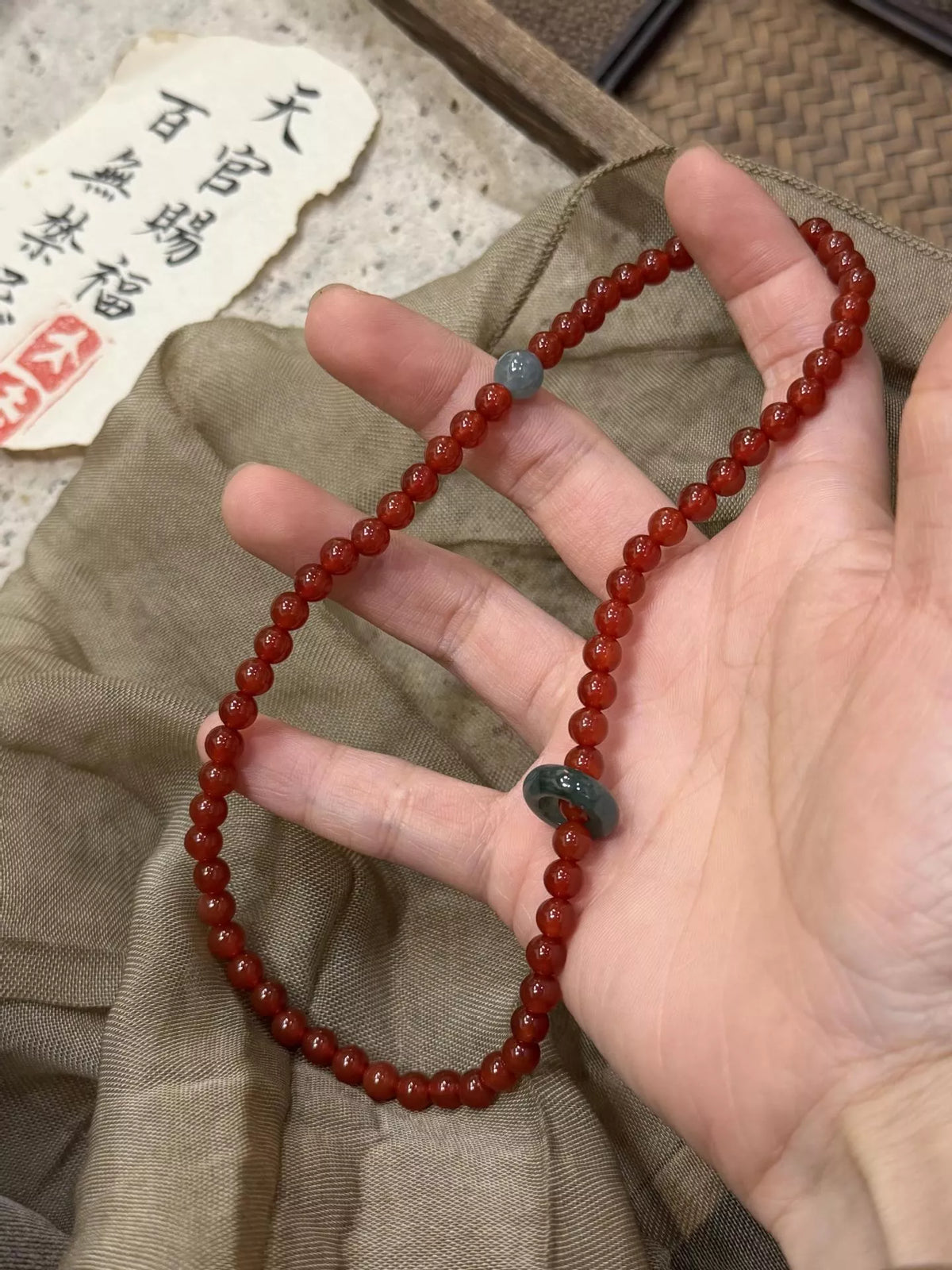 Double-layer agate bead bracelet with burgundy beads and a teal center bead detail
