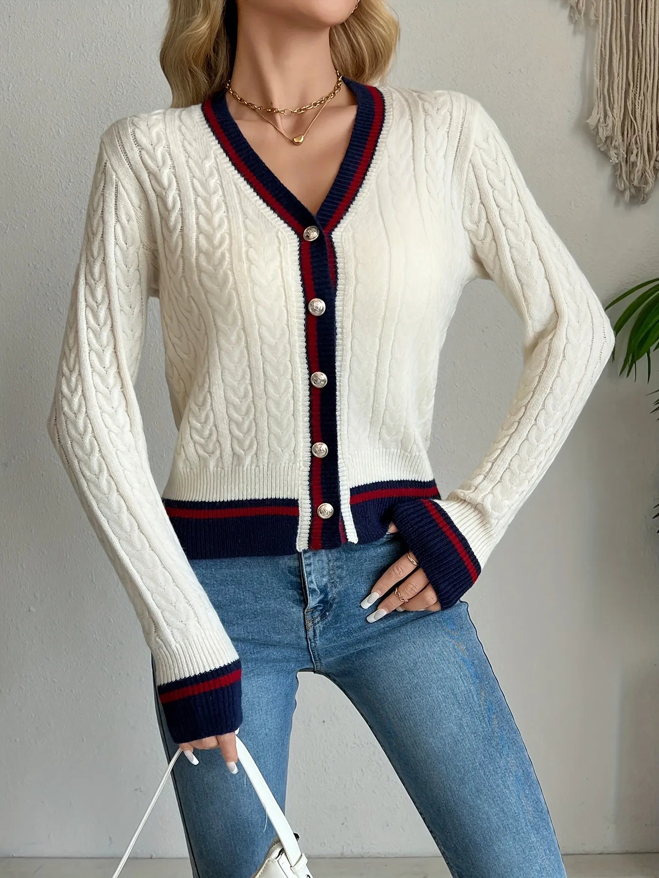 Ivory cable-knit button-front cardigan with navy and red striped collar and cuffs