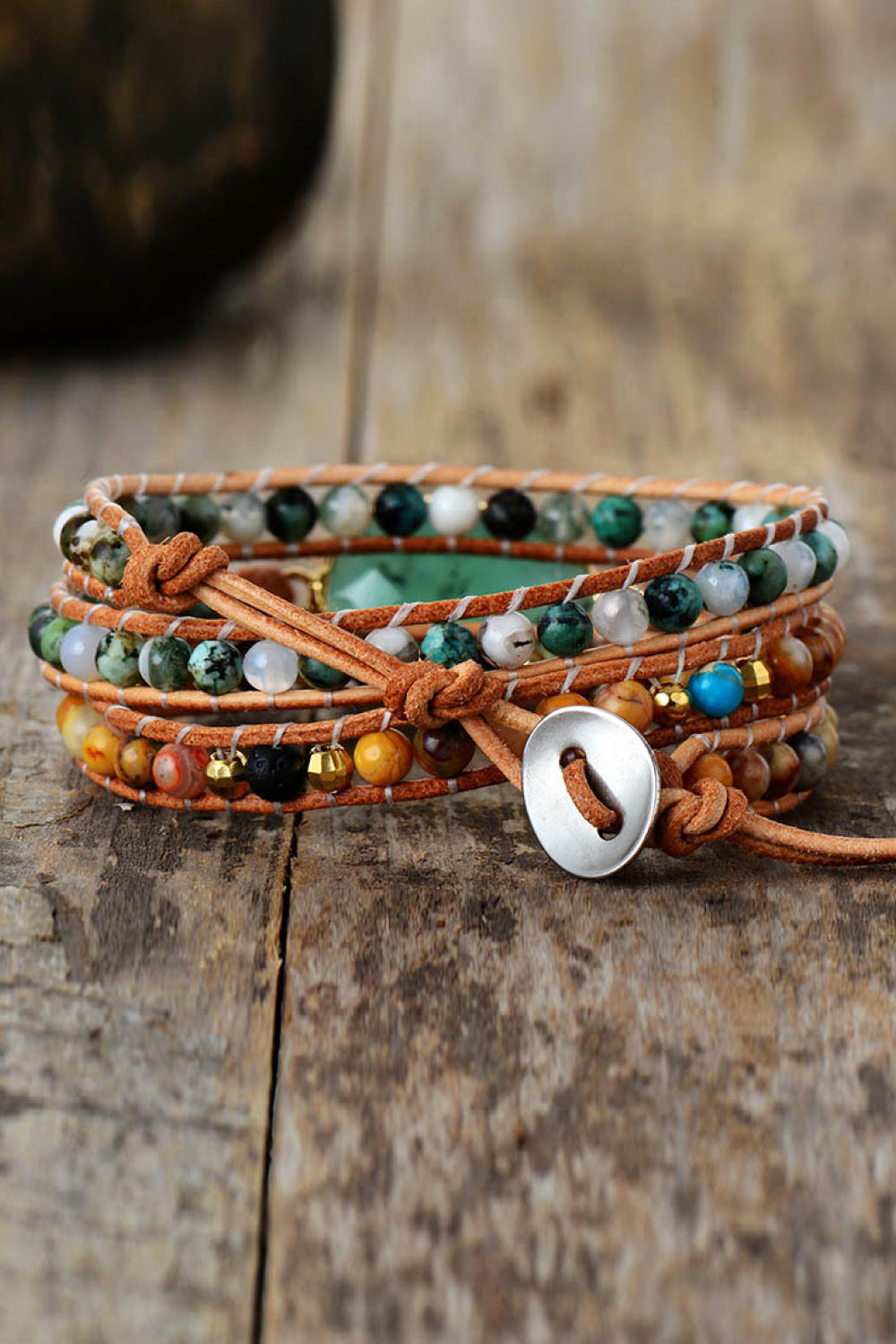Layered beaded bracelet with turquoise beads and silver oval charm on braided ties