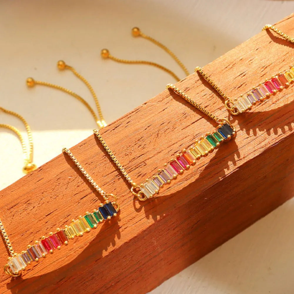 Pair of multicolor zircon tennis bracelets with gold-tone links and beads