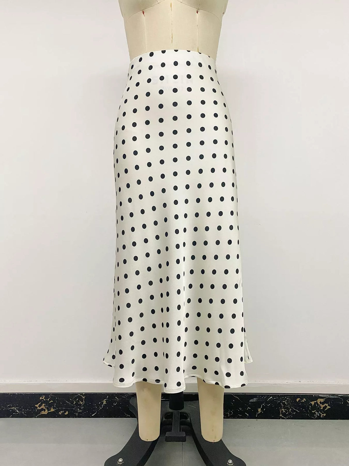 Beige polka dot stretch midi skirt on mannequin, straight front view