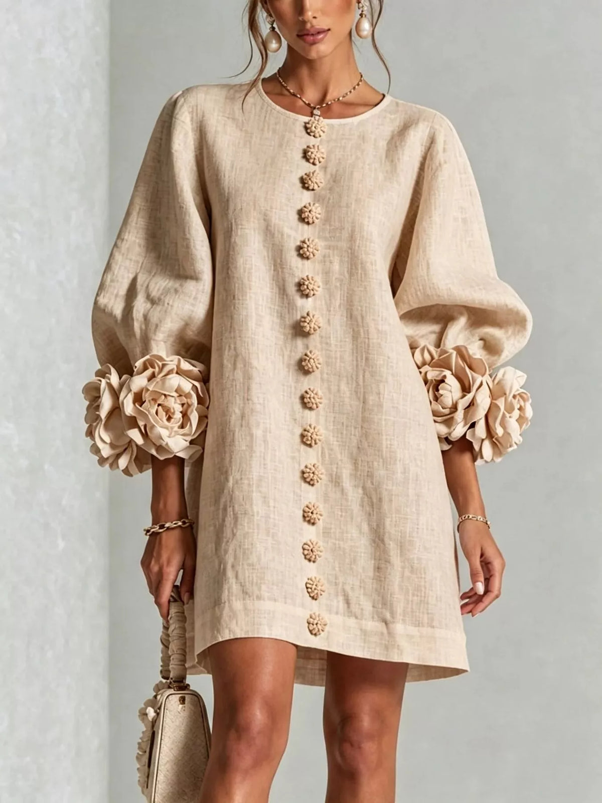 Tan linen mini dress with round neck, vertical 3D floral button trim and puff sleeves
